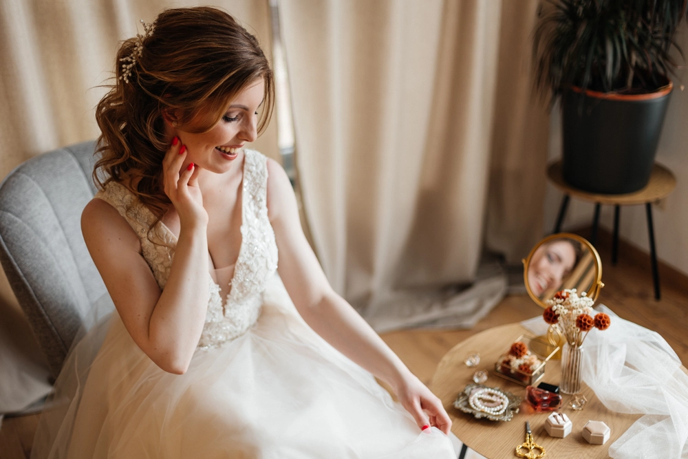 Ein natürliches, ungestelltes Portrait der Braut im Fensterlicht, voller Vorfreude während des Getting Ready.