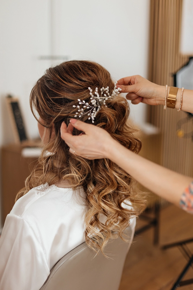 Die Braut beim Styling: Nahaufnahme des filigranen Haarschmucks in der lockeren Brautfrisur.