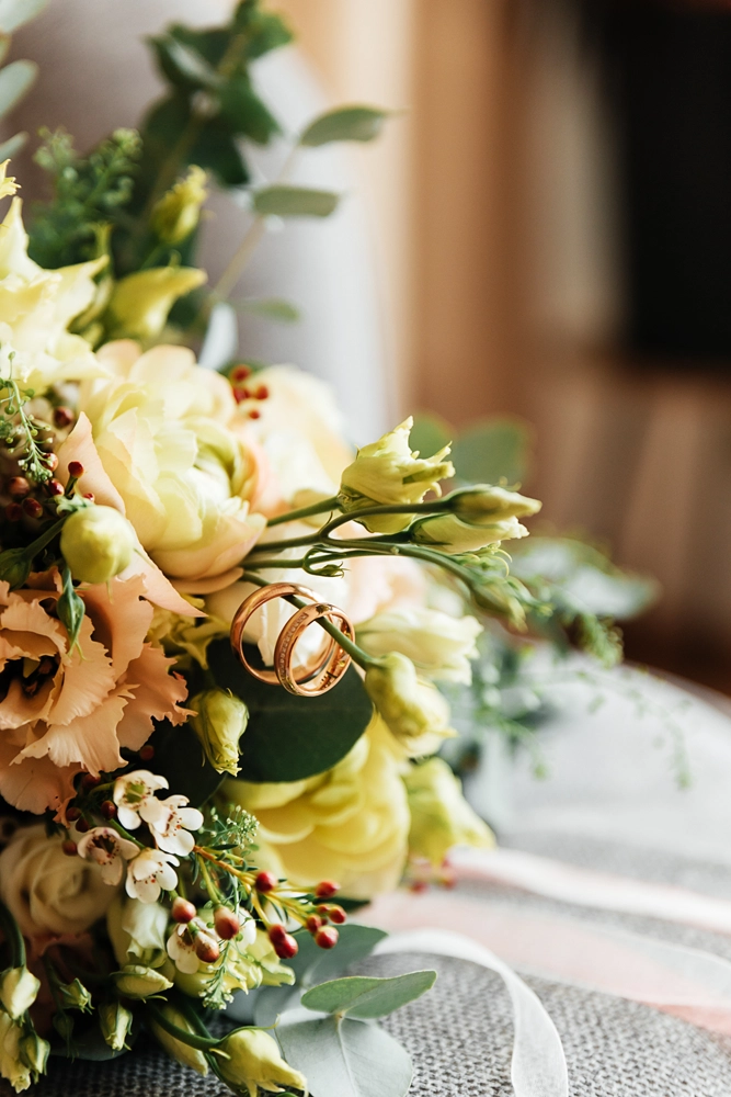 etailaufnahme der goldenen Eheringe und des Brautschmucks, ästhetisch arrangiert als Flatlay im Editorial-Look.