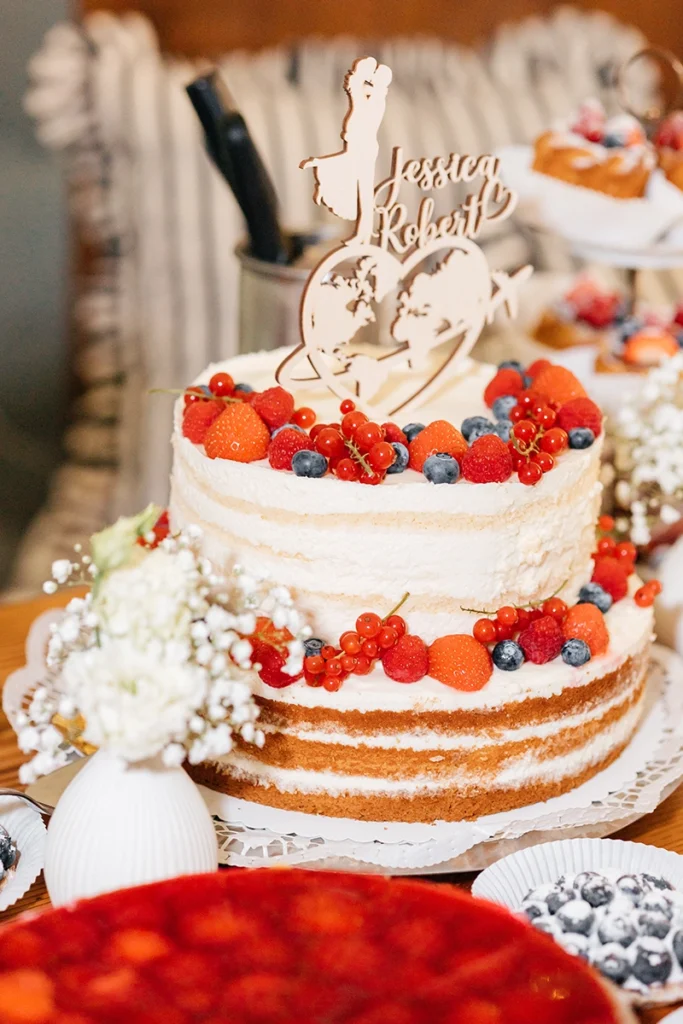 Zweistöckige Hochzeitstorte mit Erdbeeren und verschiedenen Beeren