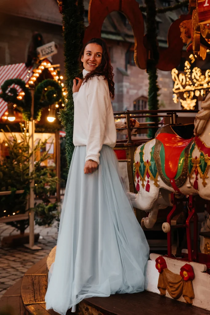 Romantisches Weihnachtsportrait einer Frau am Karussell auf dem Nürnberger Christkindlesmarkt im warmen Abendlicht.