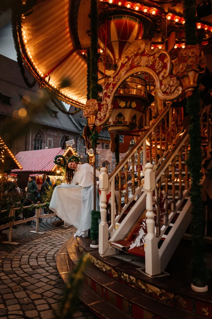 Weihnachtliches Portraitshooting vor dem beleuchteten Karussell auf dem Nürnberger Christkindlesmarkt.