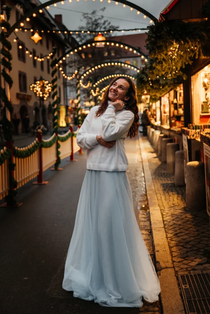 Emotionales Nahportrait einer Frau unter weihnachtlichen Lichterbögen auf dem Nürnberger Christkindlesmarkt.