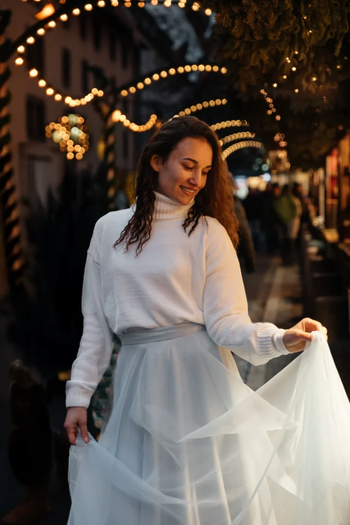 Emotionales Nahportrait einer Frau unter weihnachtlichen Lichterbögen auf dem Nürnberger Christkindlesmarkt.