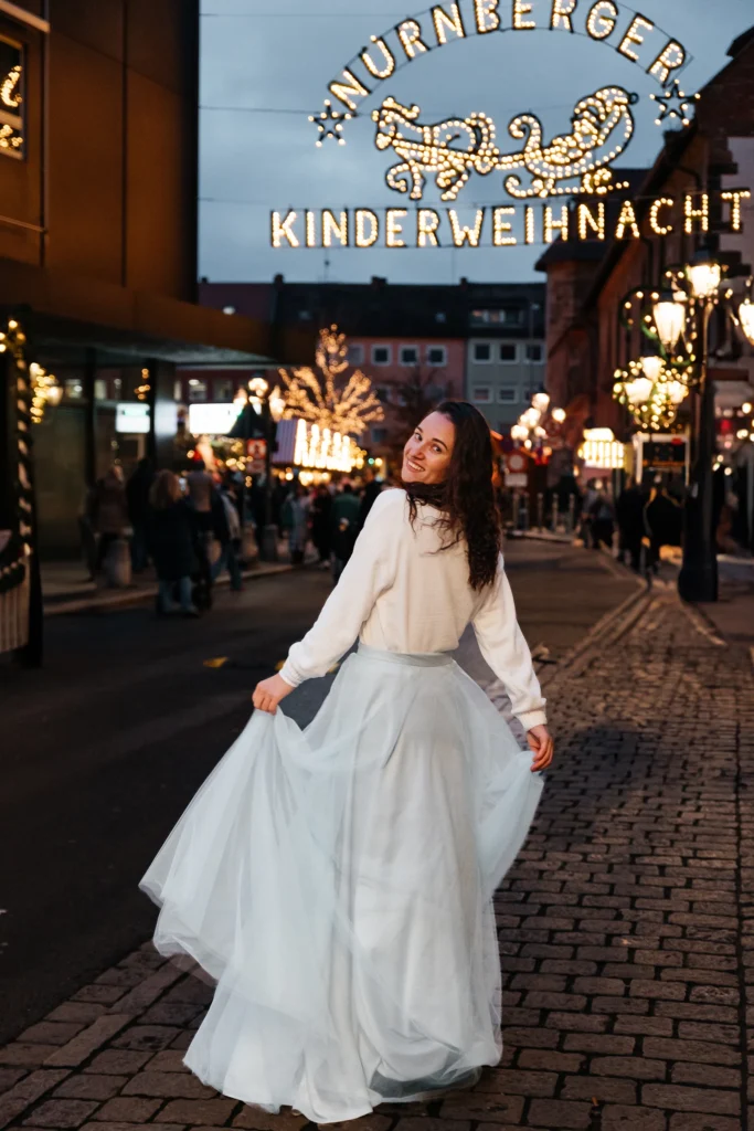 Natürliches Portrait einer Frau im Abendlicht auf der Nürnberger Kinderweihnacht mit festlichen Lichterketten.