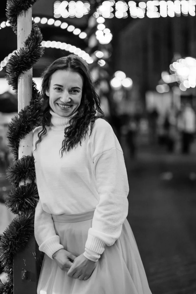 Stimmungsvolle Aufnahme einer Frau auf leuchtendem Christkindlesmarkt in Nürnberg.