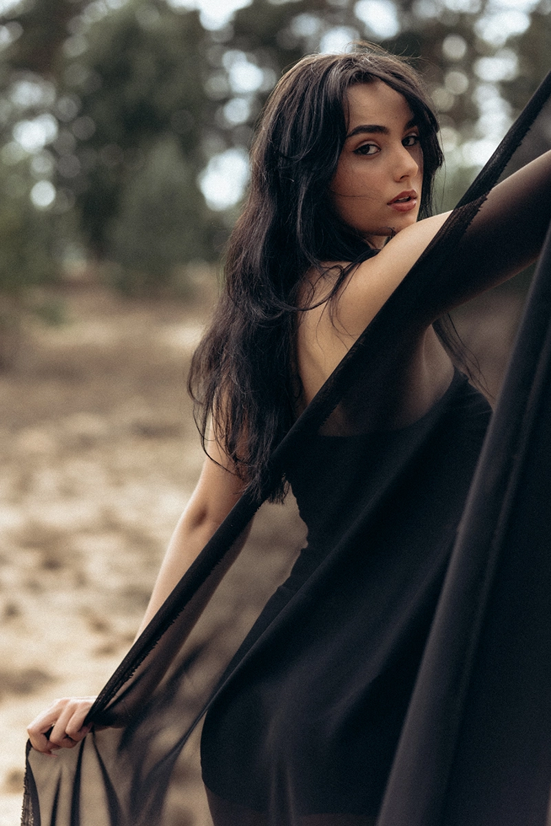 Künstlerisches Fine Art Portrait outdoor in Bayern: Frau mit wehendem schwarzen Stoff im Wald, emotionale Bildsprache.