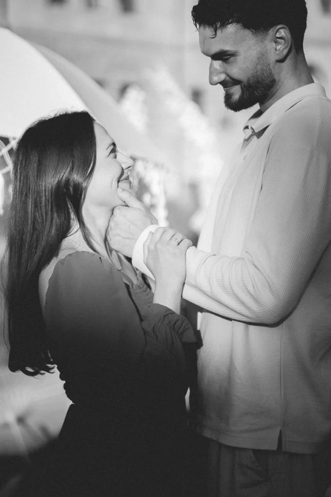 Emotionales Portrait bei einem Paarshooting: Mann hält sanft das Kinn der Frau, intimer Moment und Editorial-Ästhetik in urbaner Umgebung.