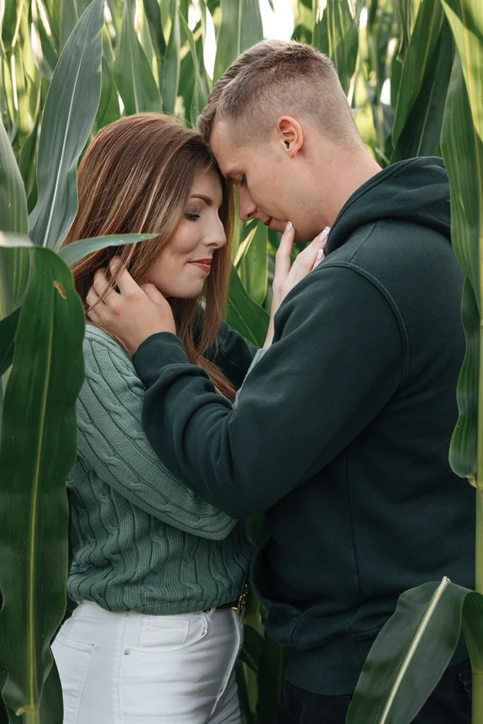 Romantisches Paarshooting im Nürnberger Land: Paar steht im Maisfeld, stimmungsvolle Aufnahme mit weichem Licht und künstlerischer Unschärfe im Vordergrund.