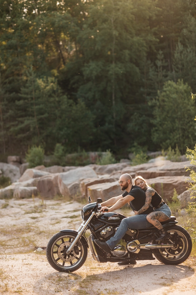 Paar auf Motorrad im warmen Gegenlicht der untergehenden Sonne.