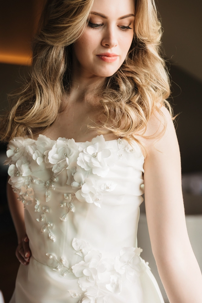 Detailansicht der 3D-Blumenapplikationen auf der Corsage des Brautkleides.