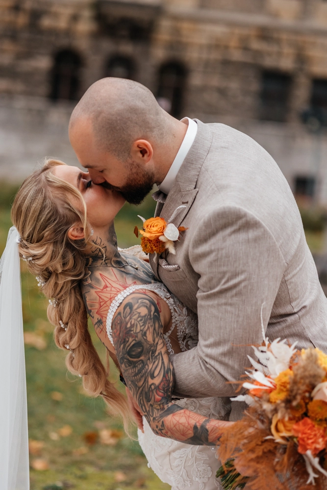 Romantischer Kuss vor Schloss-Kulisse: Bräutigam neigt die Braut leicht nach hinten (Dip-Pose). Leidenschaftlicher Moment im Schloss Faber-Castell Park