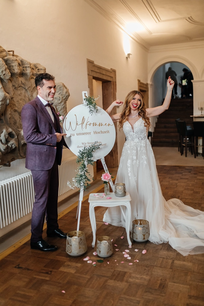 Elegantes Ganzkörperfoto des Paares im Saal. Zeigt das Brautkleid und den Anzug im Detail.
