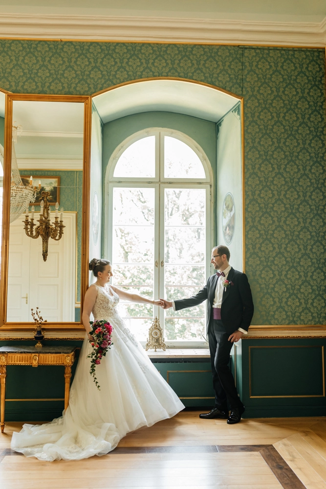 Elegantes Brautpaar im grünen Saal mit Kronleuchter