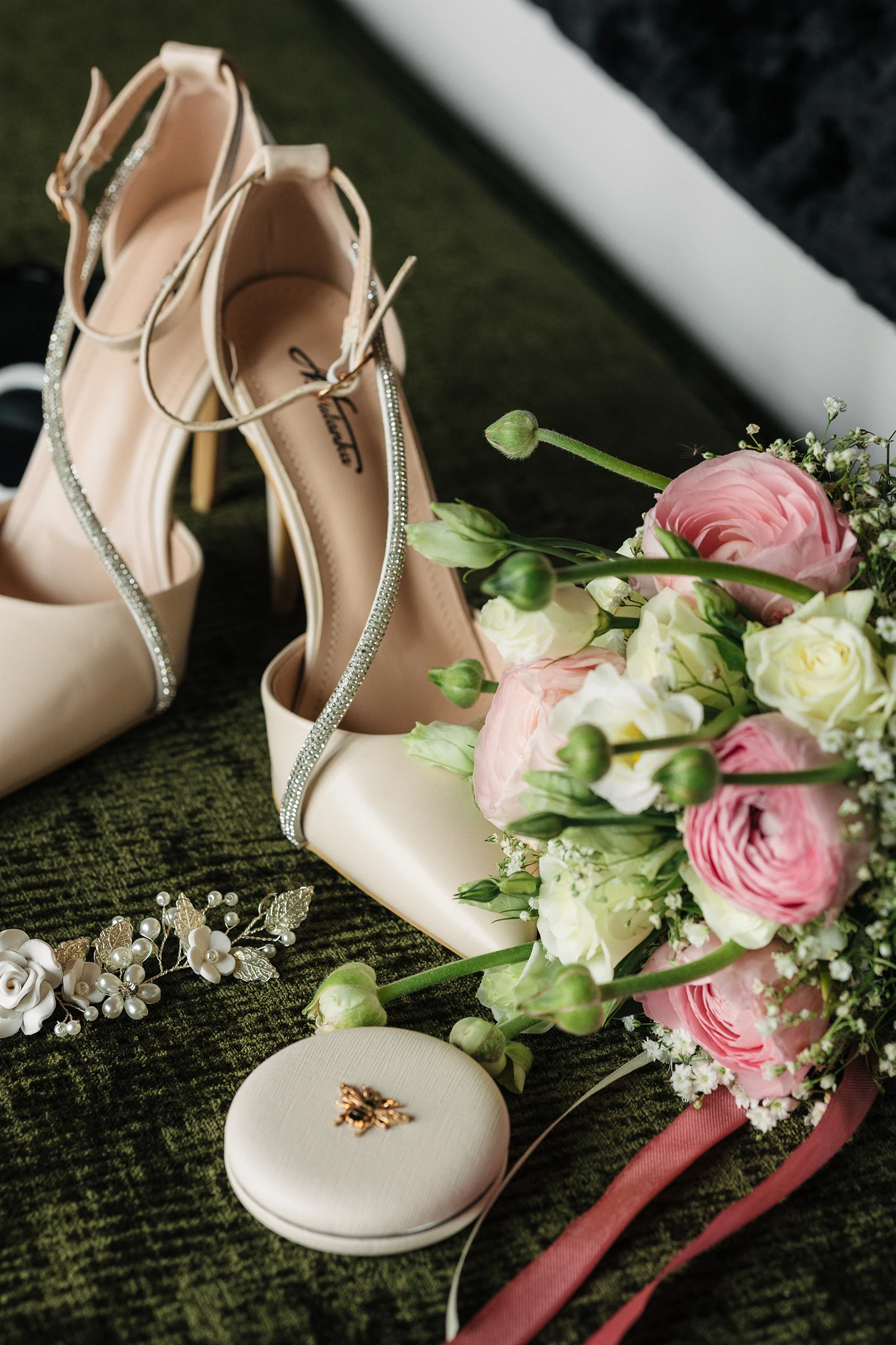 Elegante Brautschuhe und Brautstrauß, ästhetisch arrangiert auf grünem Untergrund.