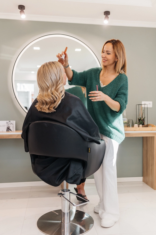 Friseurin Nadja Laber im Gespräch mit einer Kundin beim Styling vor dem großen Rundspiegel.