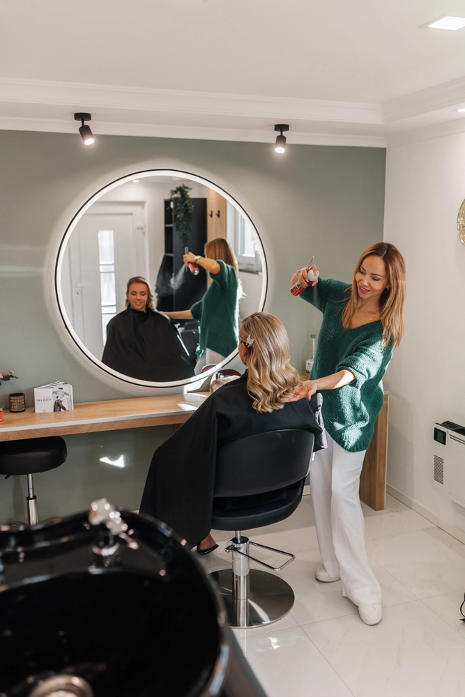 Blick in den stilvollen Friseursalon: Nadja Laber richtet die Frisur einer Kundin am Arbeitsplatz.