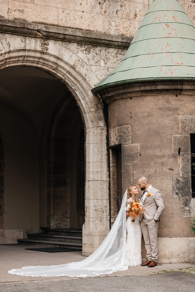 Weitwinkelaufnahme im Innenhof von Schloss Faber-Castell, imposante Architektur und Brautpaar.