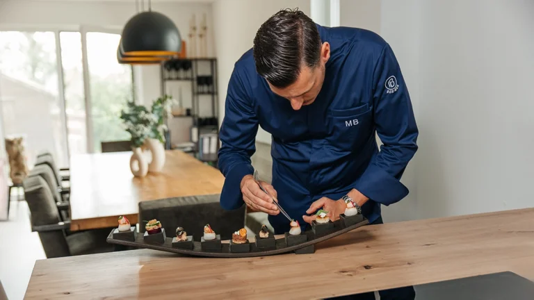 Sternekoch Marcus Bunzel richtet hochkonzentriert mit einer Pinzette feines Fingerfood an.