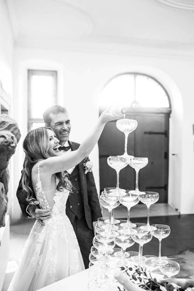 Brautpaar gießt gemeinsam die erste Flasche in den Champagne Tower.