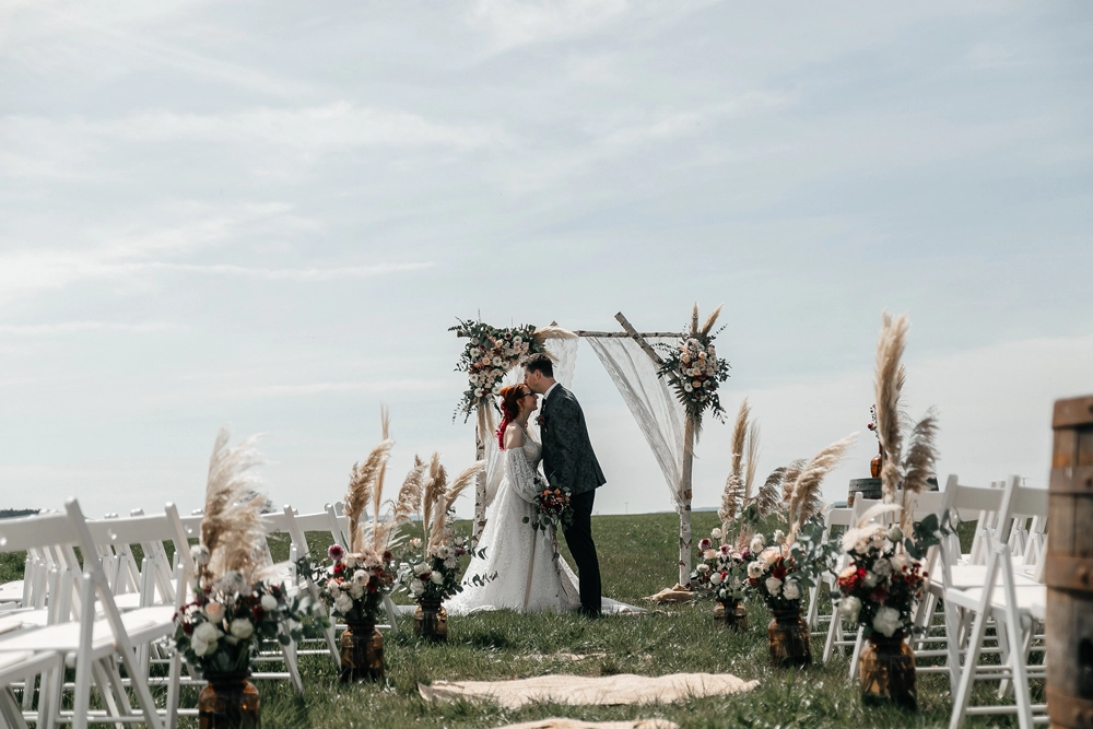 Traubogen mit Pampasgras und Blumen vor weiter Landschaft