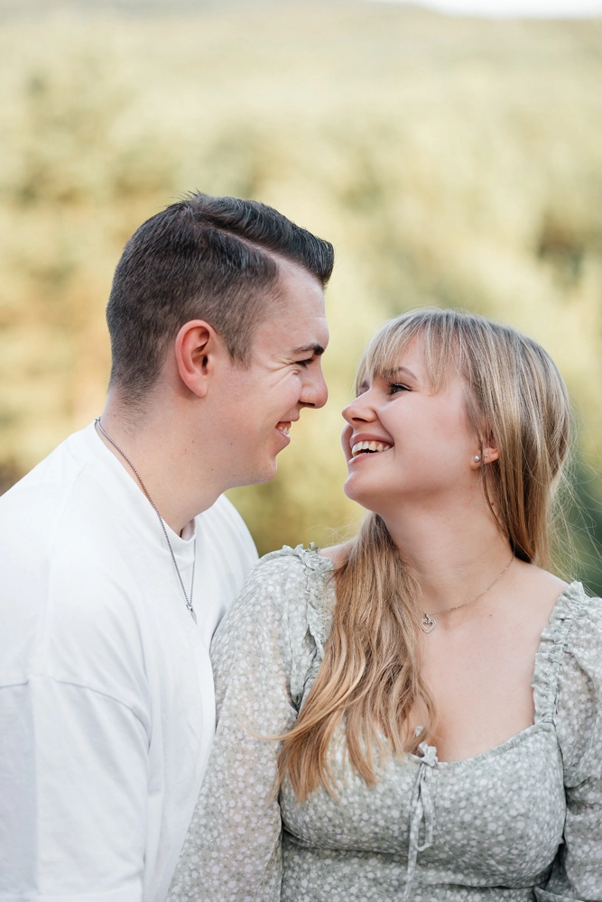 Nahaufnahme: Paar schaut sich verliebt in die Augen und lacht – authentische Emotionen.