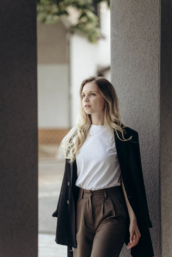 Porträt einer Geschäftsfrau im Blazer vor einem massiven Betonpfeiler, modernes und charakterstarkes Business-Shooting in Bayern.