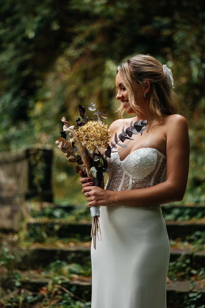 Nahaufnahme einer Braut im Profil mit einem künstlerischen Brautstrauß