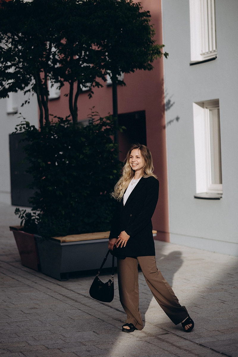 Lachende Unternehmerin mit Handtasche im urbanen Streetstyle, dynamisches Editorial Business Portrait in Nürnberg.