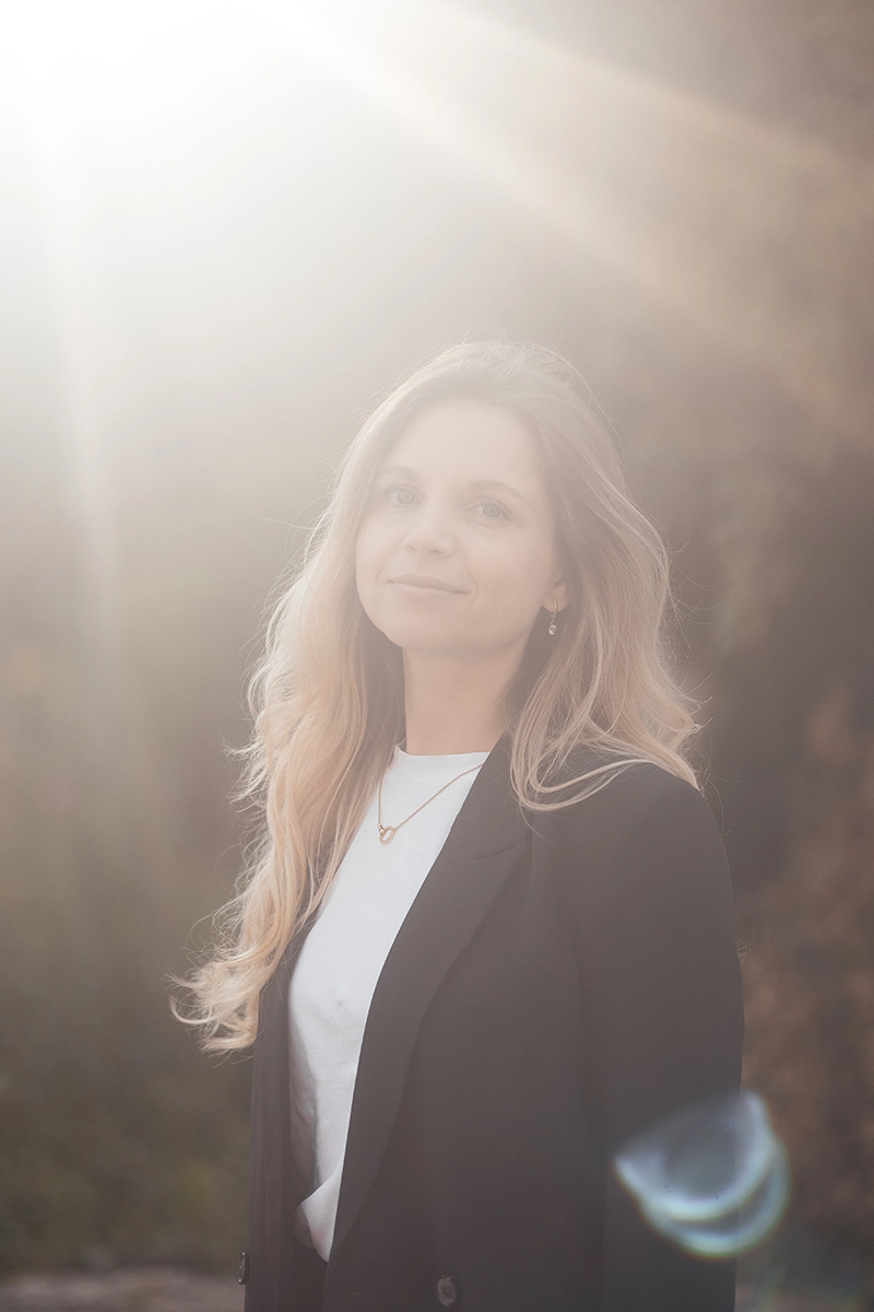 Ästhetisches Nahbereichs-Porträt einer Frau im sanften Gegenlicht, Editorial Look mit goldenem Sunflare.