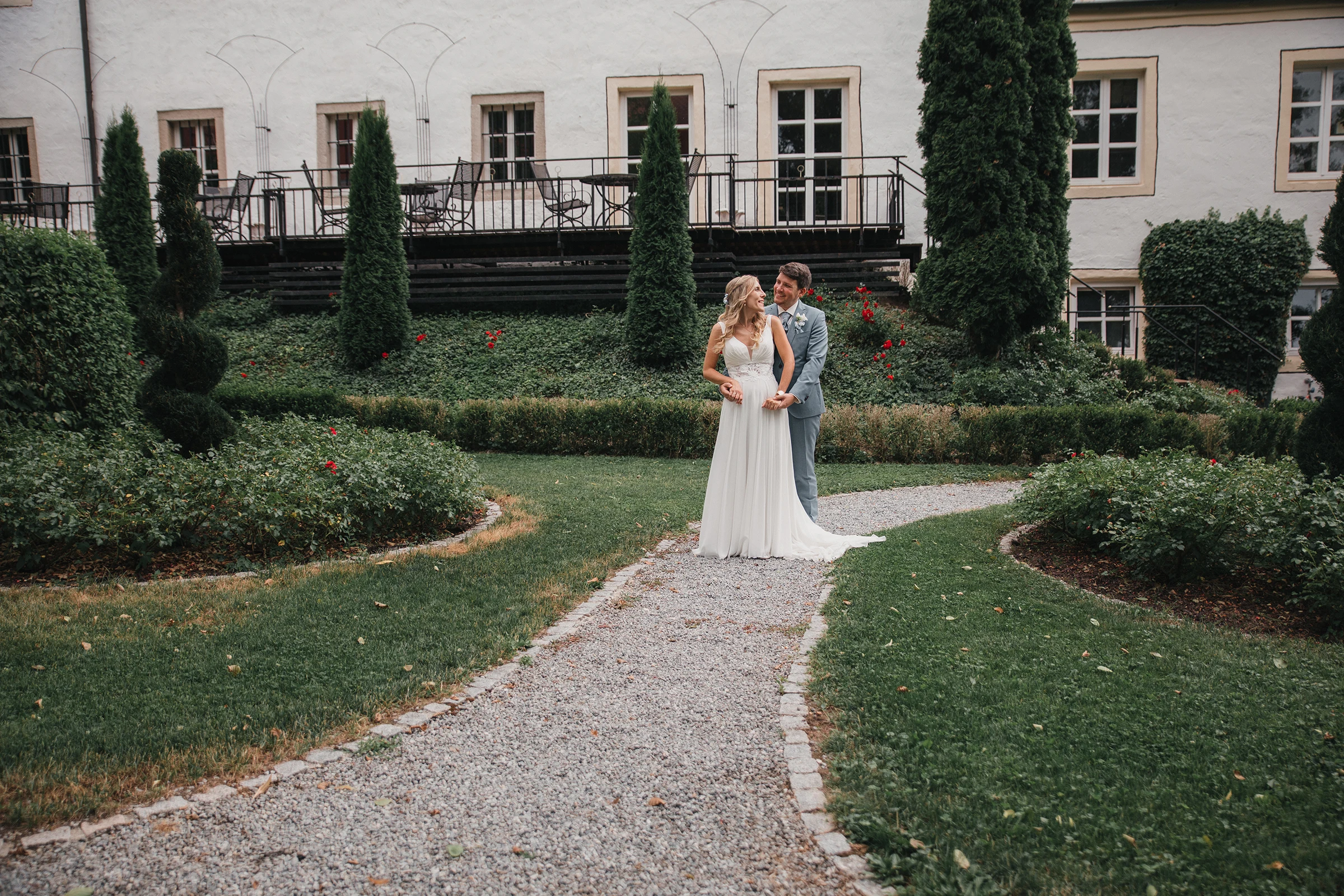 Brautpaar auf einem Kiesweg im Schlossgarten des Schloss-Hotels Neufahrn