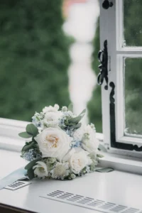 Brautstrauß mit weißen Rosen und Eukalyptus auf einer Fensterbank
