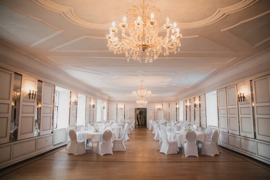 Festlich gedeckter Haunsperger Saal im Schloss-Hotel Neufahrn mit historischen Kristalllüstern