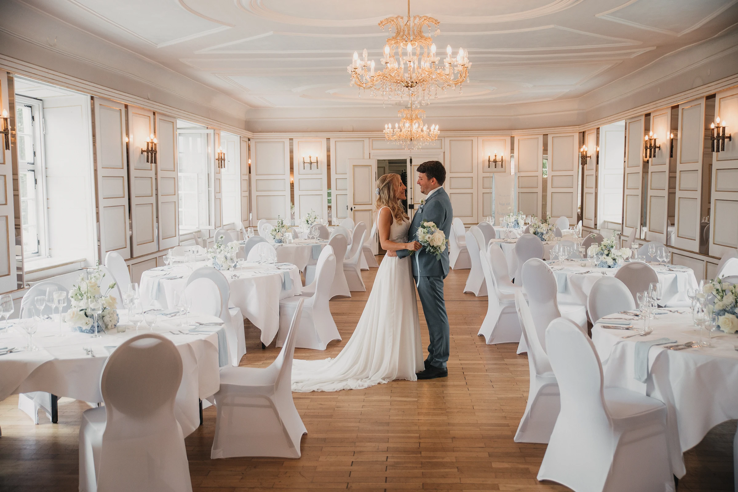 Brautpaar im festlich gedeckten Haunsperger Saal des Schloss-Hotels Neufahrn