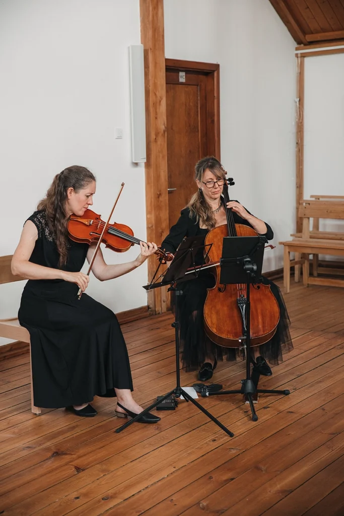 Zwei Musikerinnen spielen Violine und Cello während der Trauung