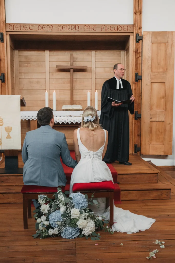 Brautpaar vor dem Altar während der Predigt bei seiner kirchlichen Trauung