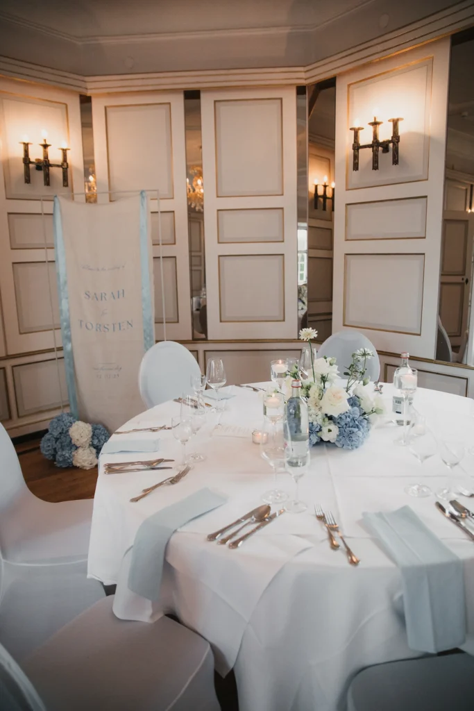 Festlich gedeckter Tisch mit weißer und hellblauer Dekoration im Haunsperger Saal