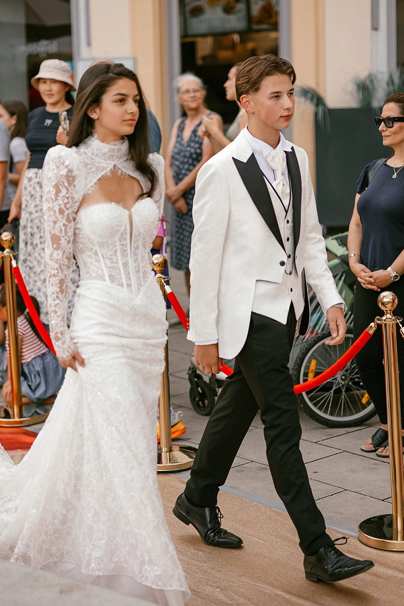 Braut und Bräutigam laufen gemeinsam über den roten Teppich der D&N Wedding Experience in Ansbach.