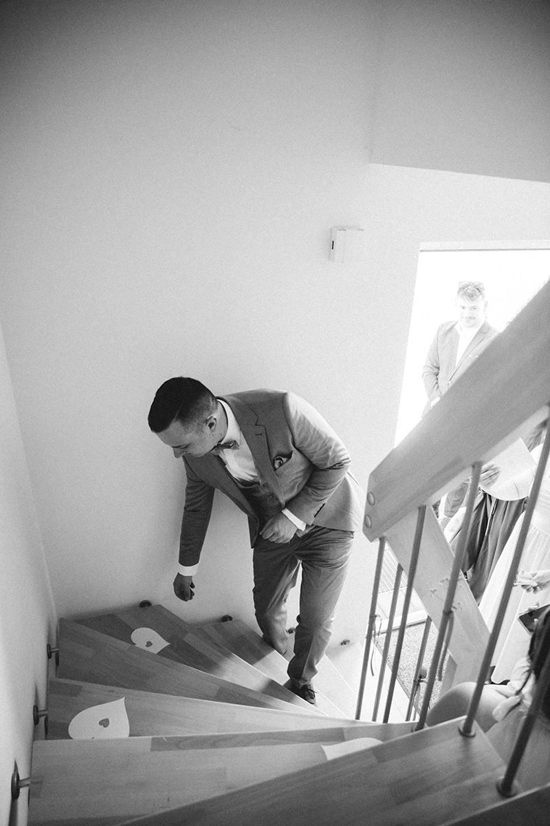Der Bräutigam steigt während des Brautauskaufs eine mit Papierherzen geschmückte Treppe hinauf.