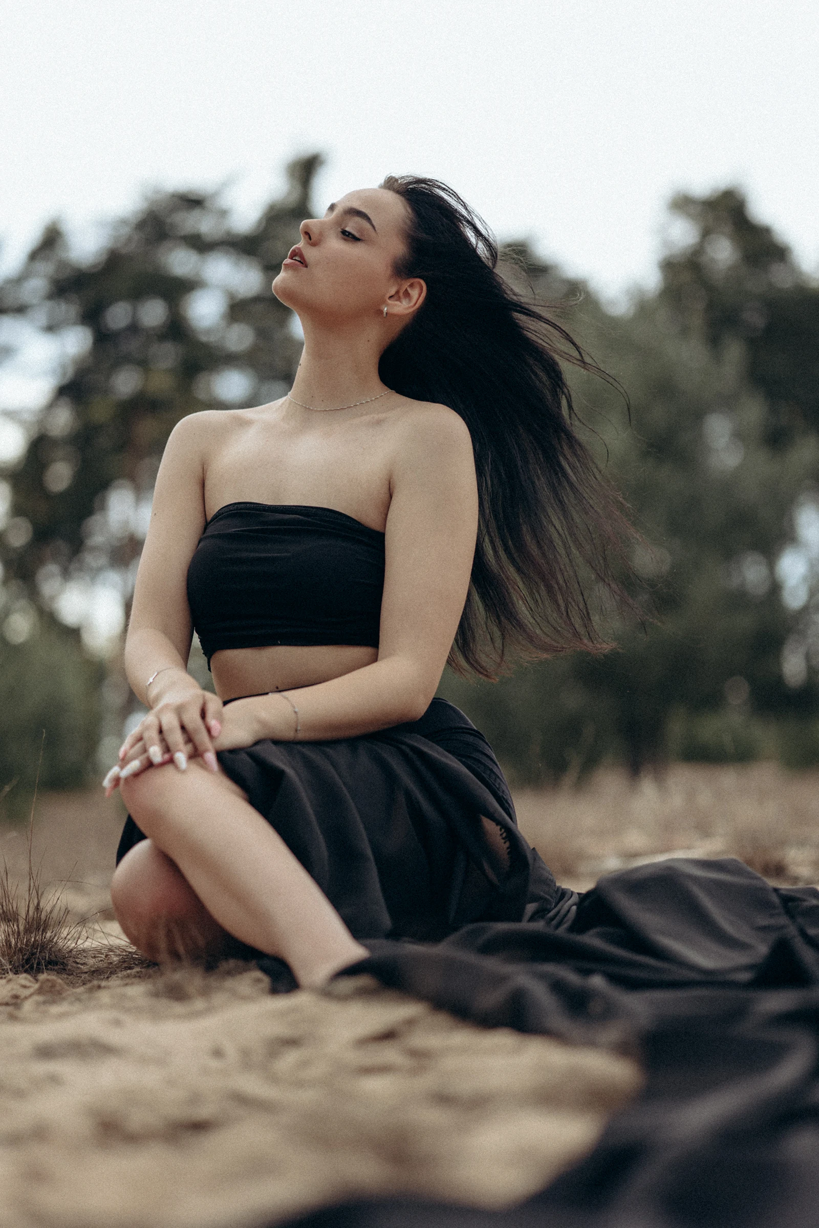 Frau in schwarzem Kleid bei einem Portraitshooting draußen in der Natur