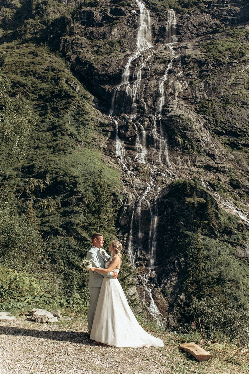 Das Brautpaar steht vor dem Wasserfall nahe der Grawandhütte.