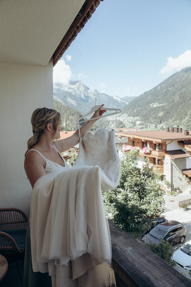 Romy steht während ihres Getting Readys auf dem Balkon mit Blick auf Mayrhofen.