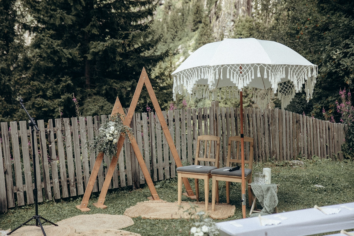 Vorbereiteter Trauplatz mit Holzgestell und Sitzplätzen im Garten der Grawandhütte.